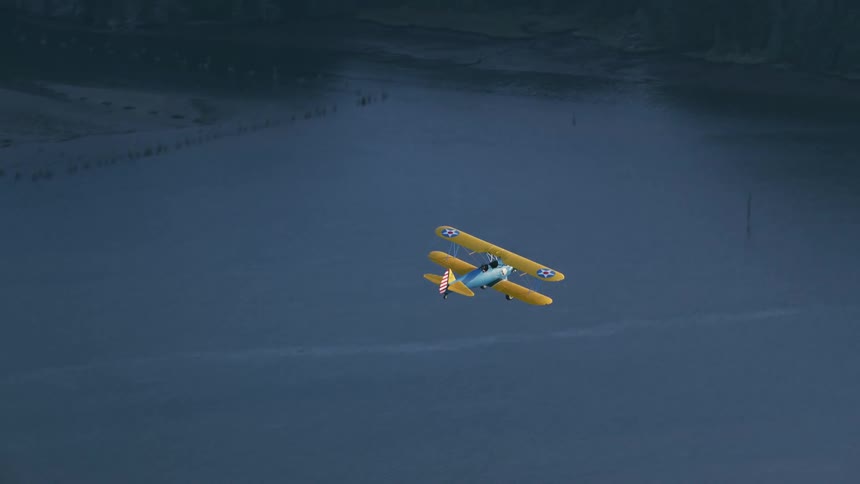 An aerial view of a plane flying over the water