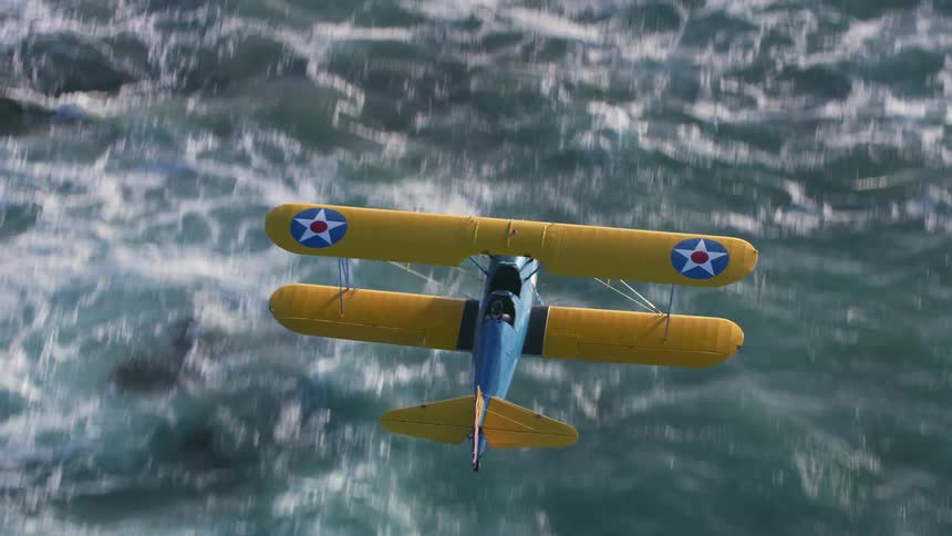 Yellow and blue biplane flying over the ocean waves at morning