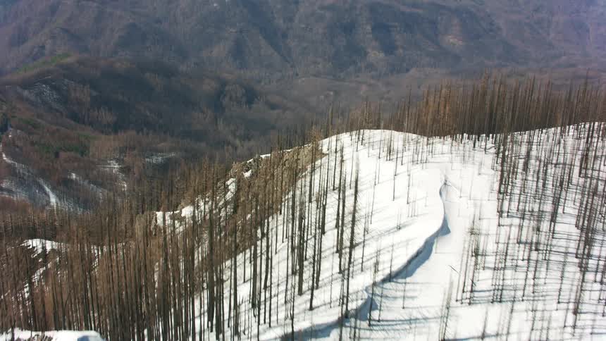 Aerial view of a valley behind the snow covered mountain