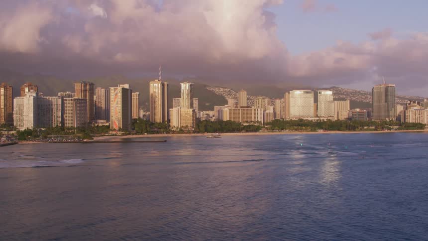 Aerial view of a waterfront city skyline near the beach at evening