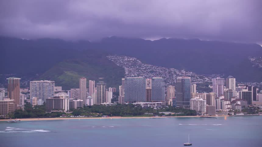 Skyscrapers of different heights and colors fill the coastline along the ocean