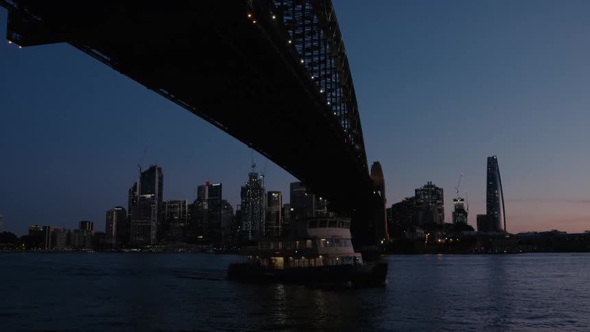 A view of a ship sailing on the water under a bridge