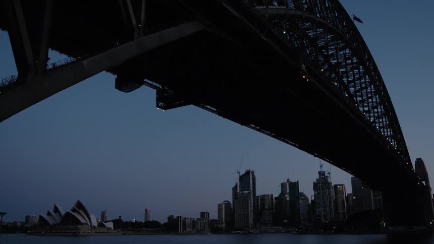 A bridge over a river with buildings the sky and clouds in the background