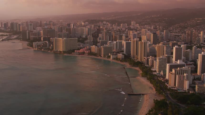 A coastal city with buildings and trees with the sky and clouds in the background