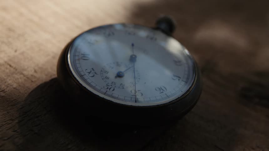 A stopwatch sitting on a table with sunlight