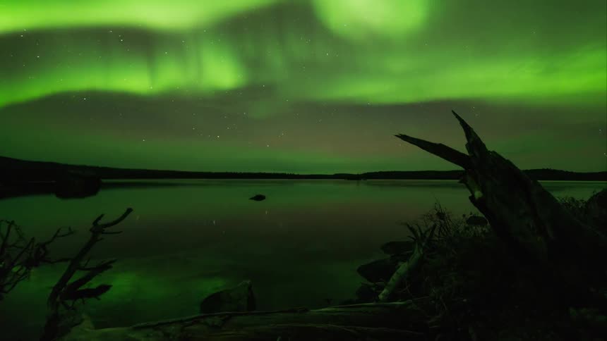 The northern lights reflecting over a body of water