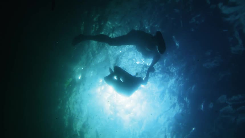 Underwater footage of two people treading water