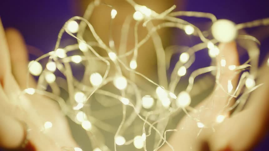 A person presses some lights together in her hands