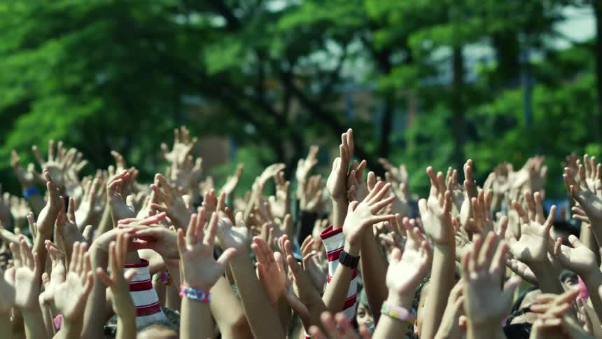 A view of a crowd of people with their hands in the air