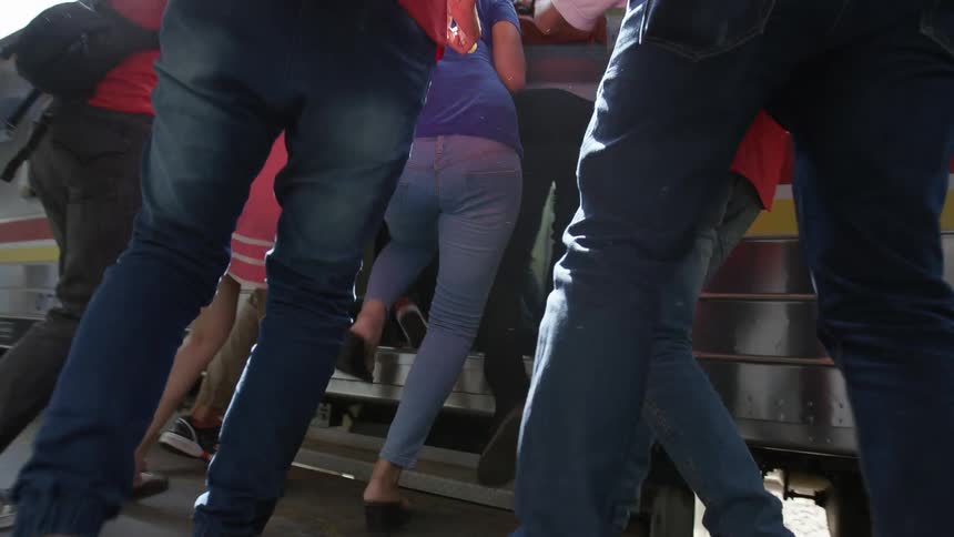 Group of friends and family rush to open train car door and help each other board at terminal