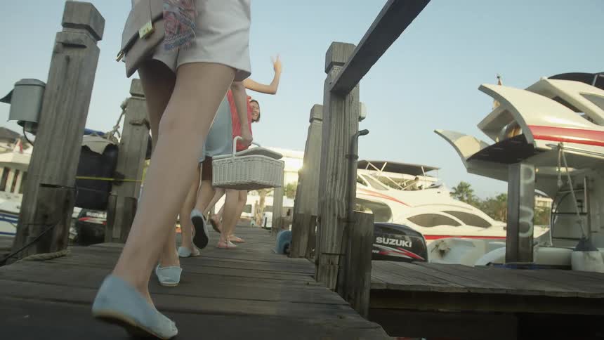 A group walk on the pier with a picnic basket