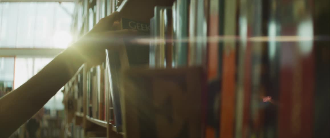 A person grabs a book from the shelf