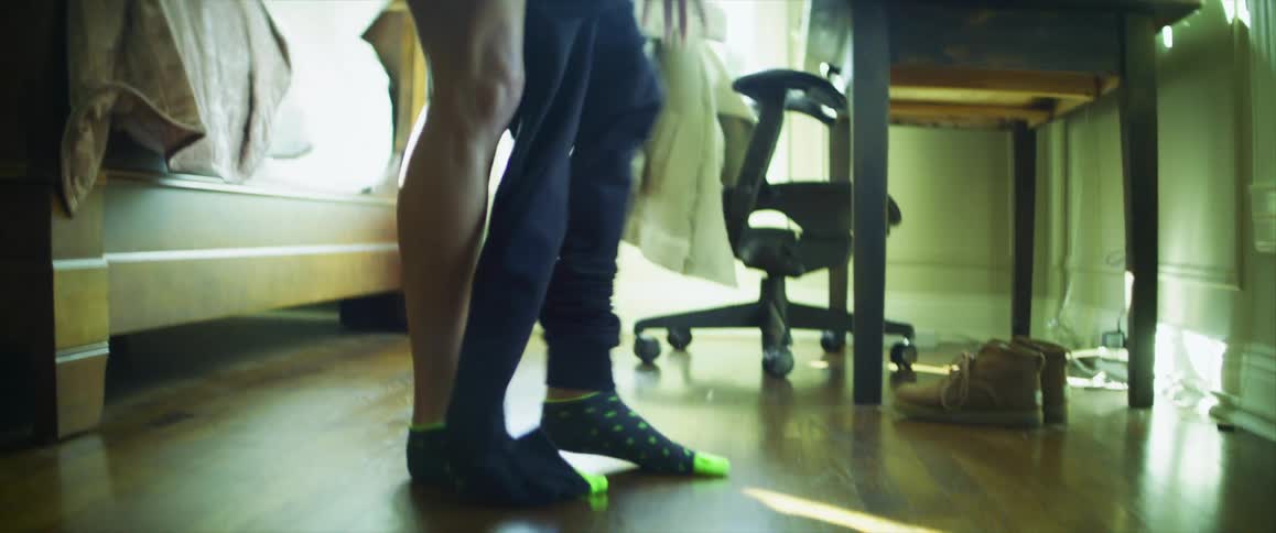 A woman is getting dressed in her bedroom