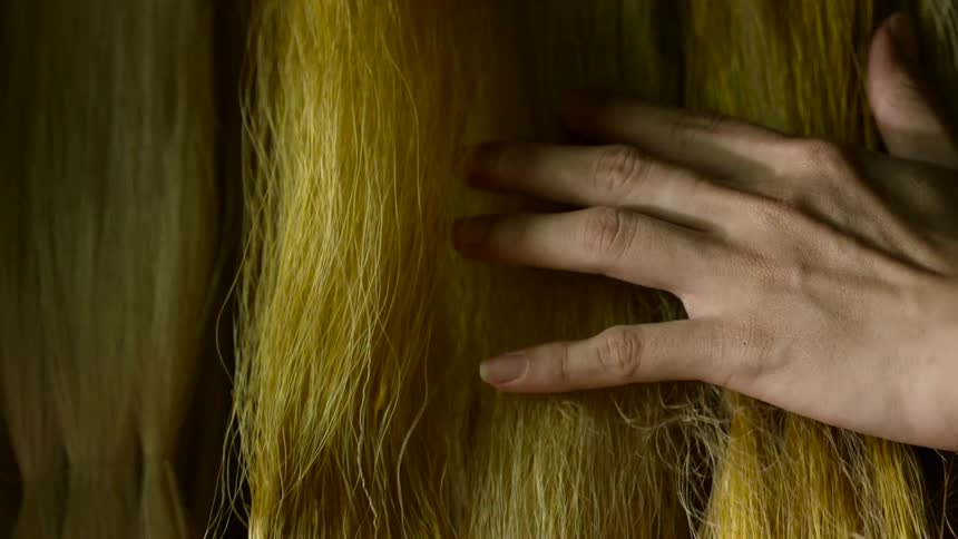 A person is touching rows of hair extensions