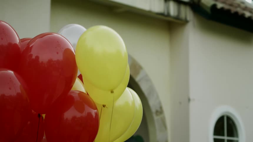 A balloon floats away from a group of balloons and into the sky