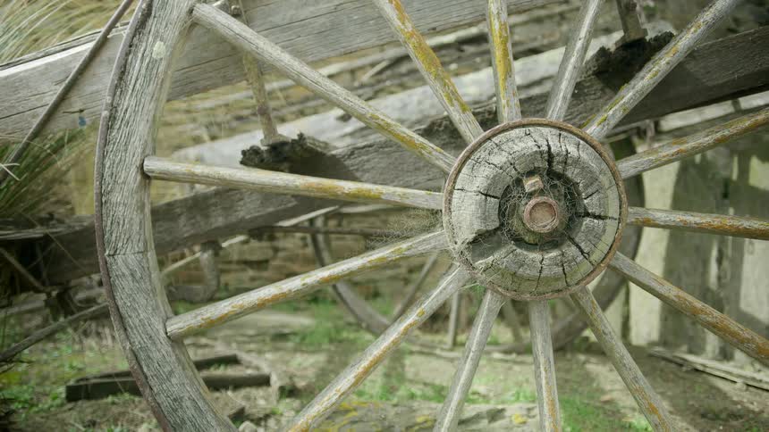 An old wheelbarrow is splintered and worn