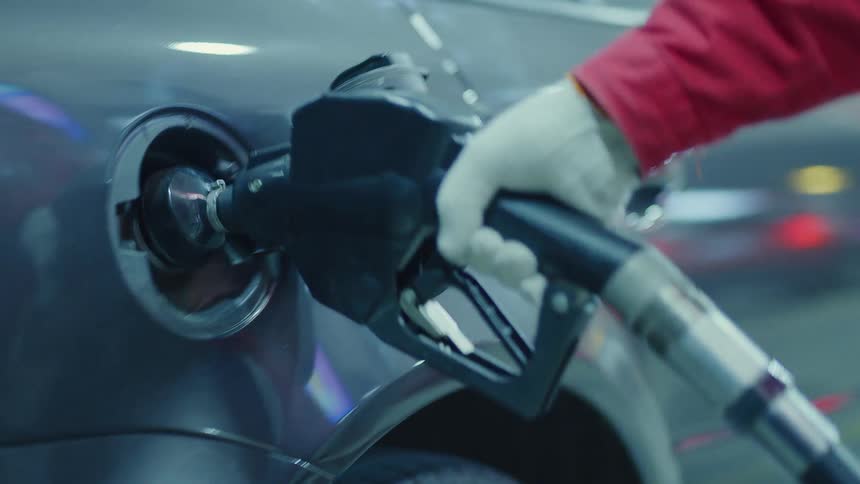 A gas station attendant pumps gas at the station