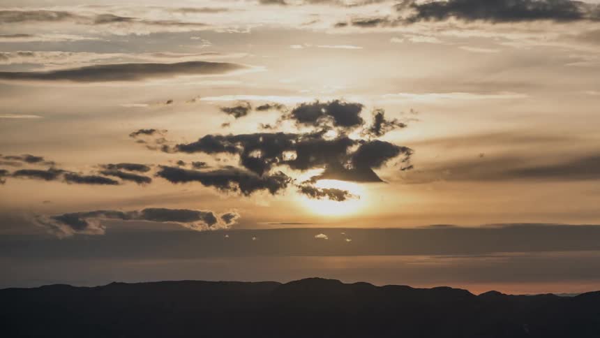 Time lapse of a golden horizon with clouds coming and going