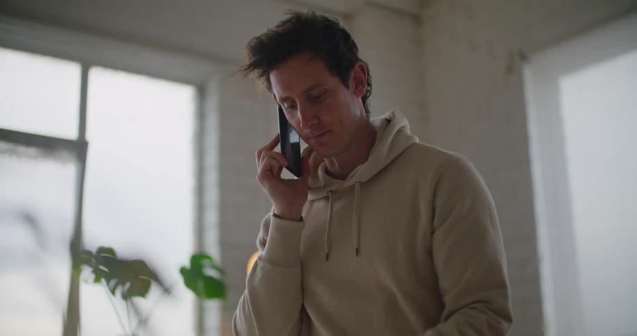 A man talking on a phone in a room