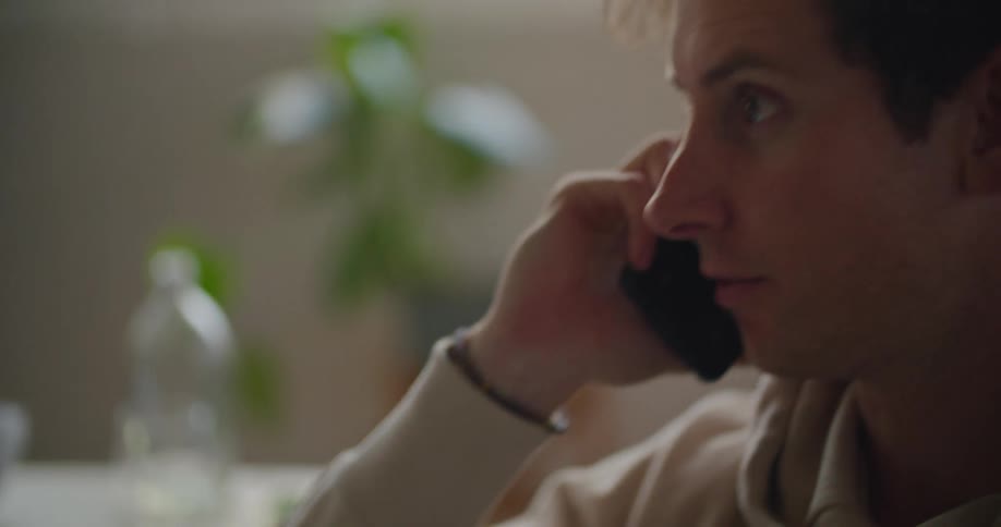 A man goes through a notebook with written notes during a phone conversation
