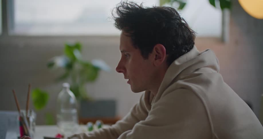A man sits in front of a laptop working at a desk
