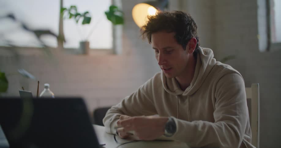 A man talking to someone else on a laptop