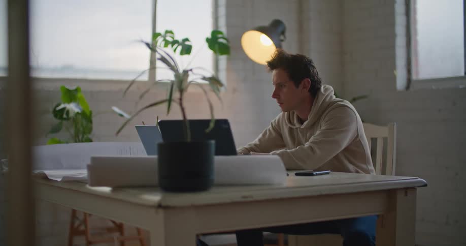 A man using a laptop then his phone
