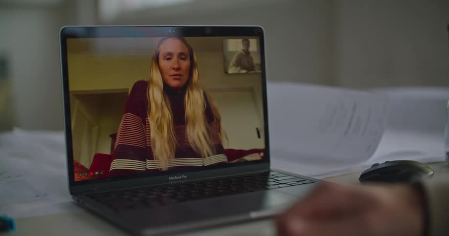 Long haired blonde woman talking on a video call on a laptop