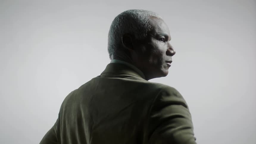 A man with his back facing forward looks to the side