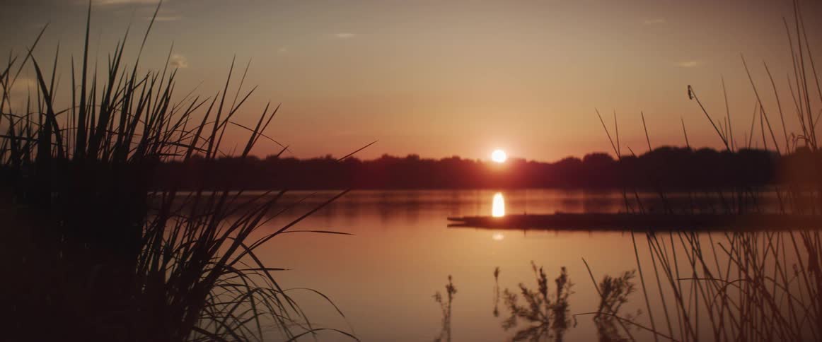 Sunset sunlight reflecting over the calm water of a river or marsh