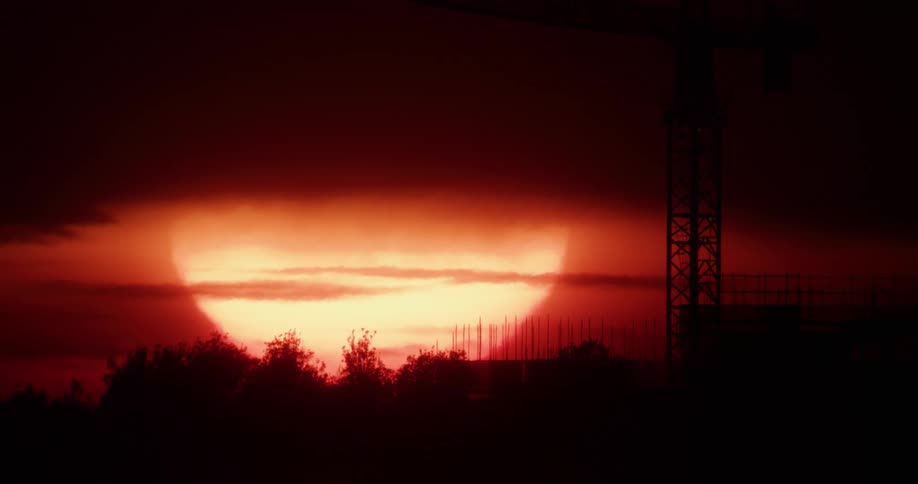 The sun is setting in the horizon on a cloudy day