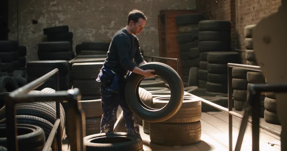 A man sorts tires in a warehouse