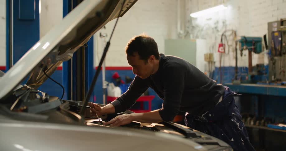A mechanic grabs a tool to work on a vehicle
