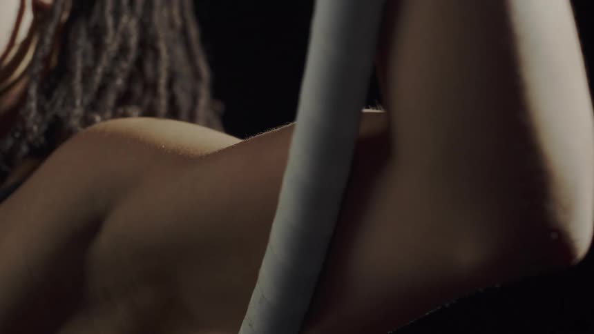 Close up of the strong muscular arm of a woman hanging from a ring