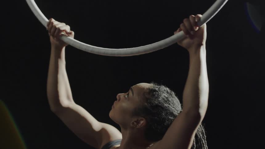 A woman is performing gymnastics under the spotlight
