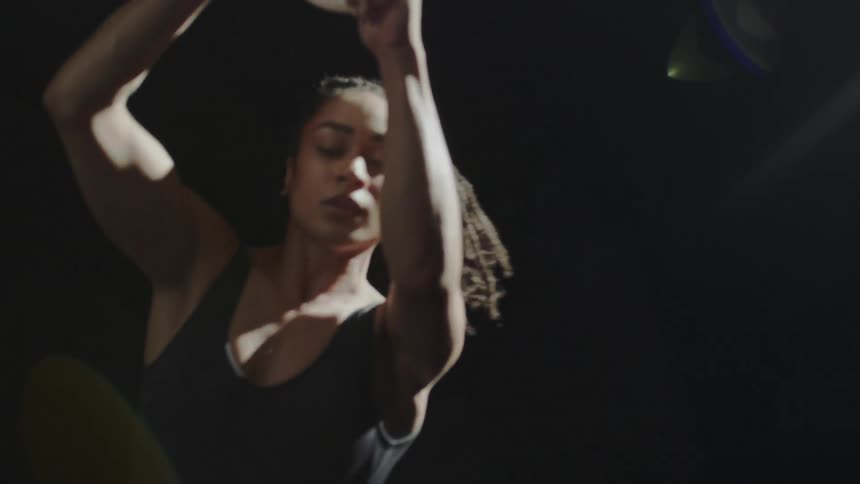 A female acrobat spinning in circles on a suspended hoop