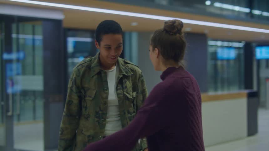 Fatigue wearing person and their significant other walk through terminal holding hands