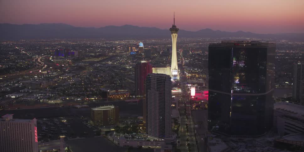 The setting sun is giving off a red sky behind the city