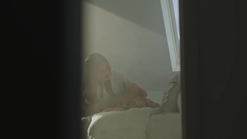 A woman lying on her stomach on a bed at home