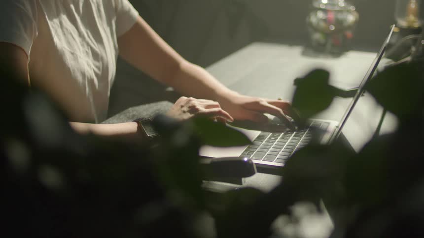 A woman is typing on the laptop