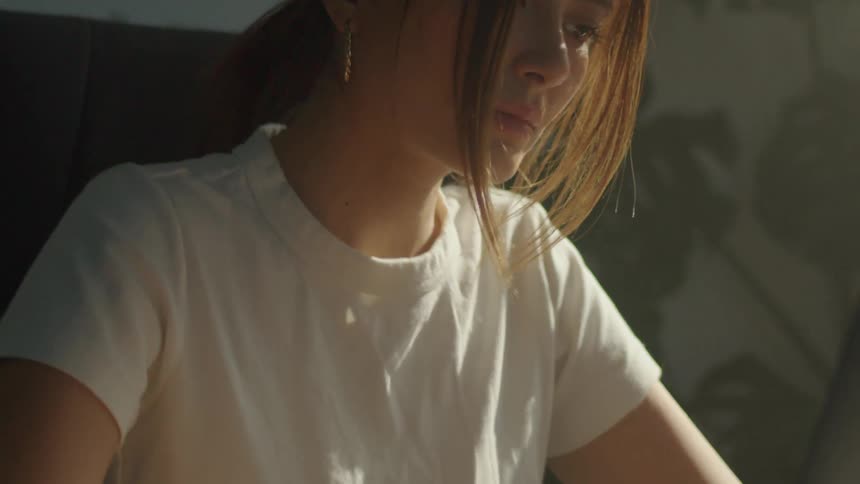 A young woman sits at a desk while typing on her computer