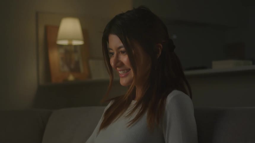 A woman is sitting on the couch talking