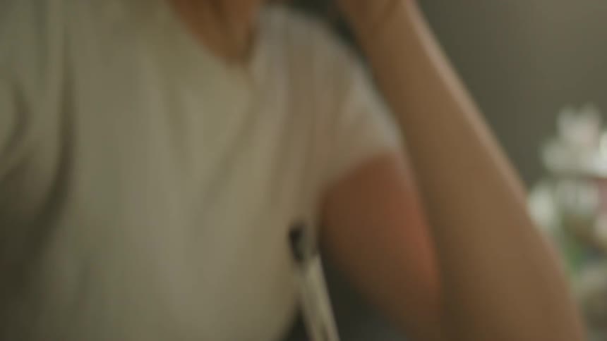 A woman is writing on a paper with a pen