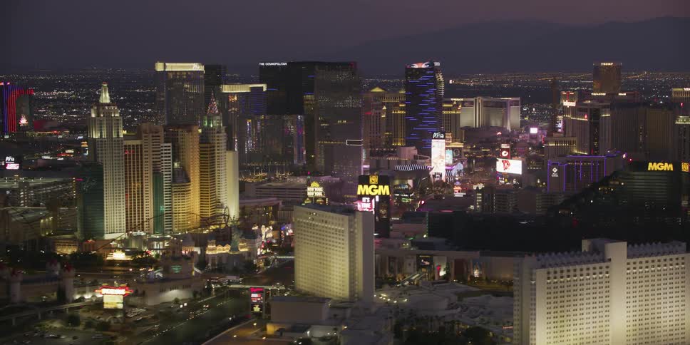 An aerial view of glowing skyscrapers in a large city at night
