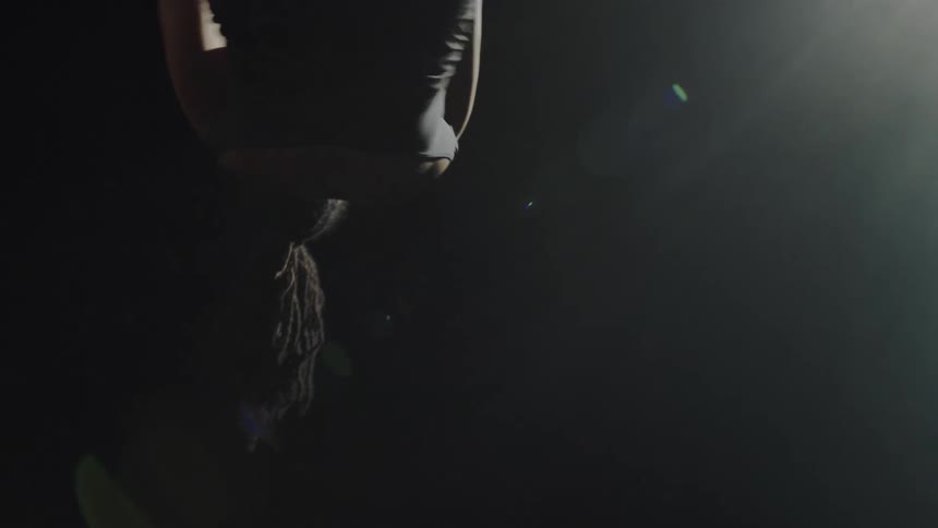 A woman spinning on a ring while grabbing with her feet