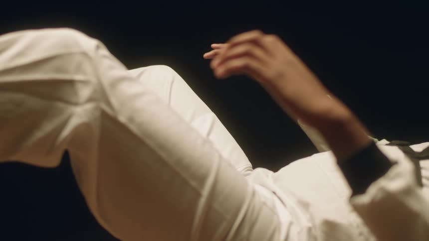 A person in a room laying on the floor with a wall in the background