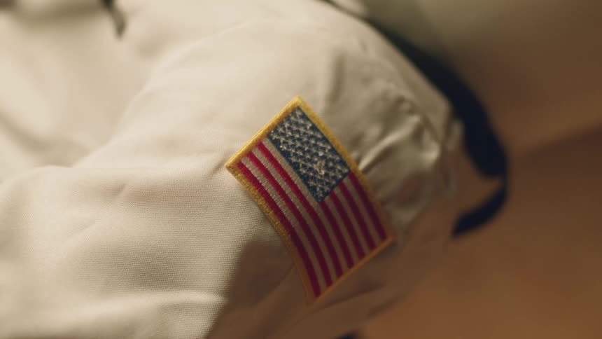 Person wears white outfit with american flag patch on the sleeve