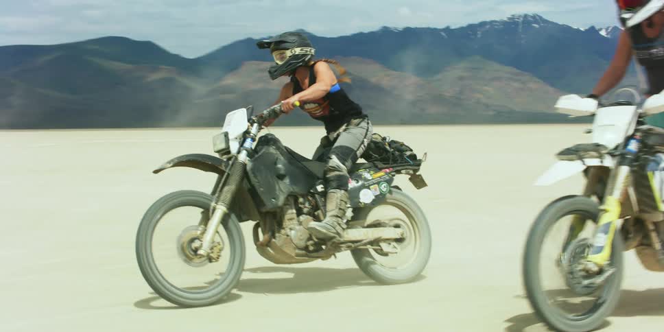 A group of people are riding dirt bikes on the field