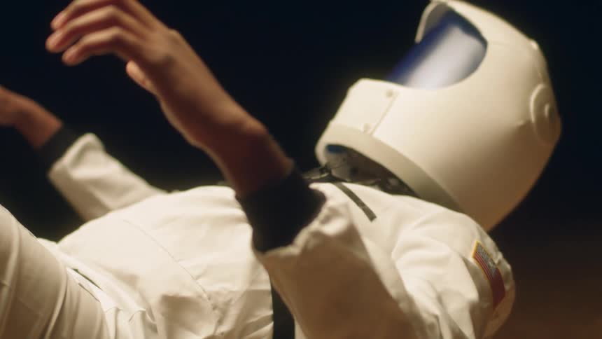 Person wearing astronaut costume floats in air
