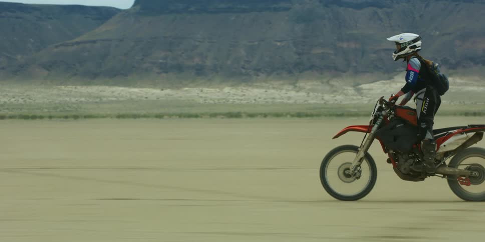 A man riding a dirt bike in the desert